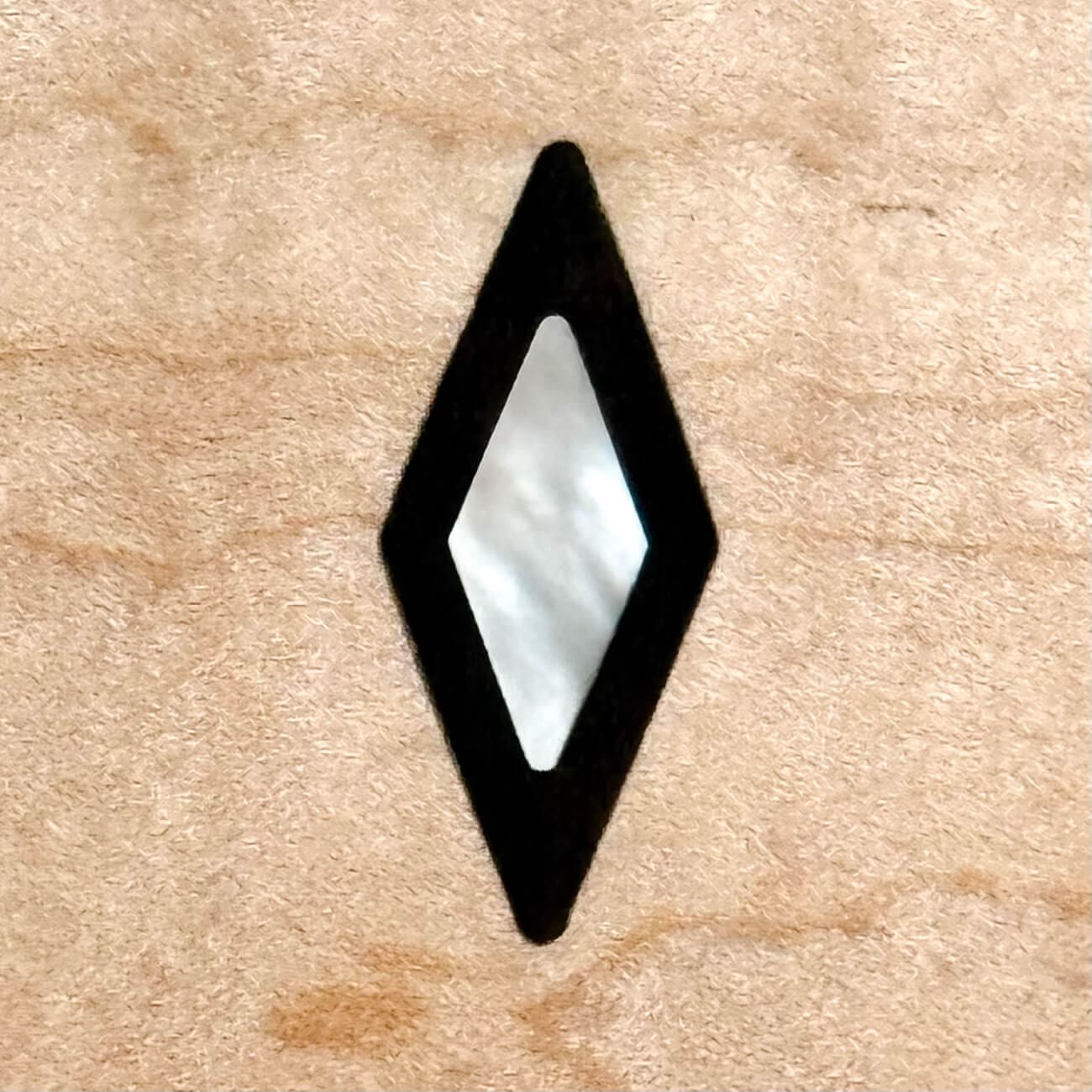 Diamond-shaped inlay on wooden surface.